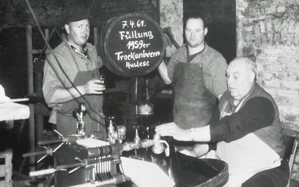 Drei Winzer im Weinkeller bei der Abfüllung einer 1959er Riesling Trockenbeerenauslese im Jahr 1961 als schwarz-weiß Bild