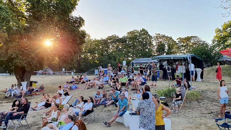 Menschen auf Wiese bei Veranstaltung Sound of Eltville im Freibad der Stadt Eltville im Sommer