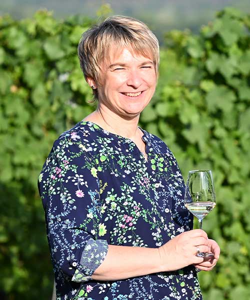 Mitarbeiterin Heidi Seidler der Winzer von Erbach eG mit Weißweinglas in der Hand im Weinberg