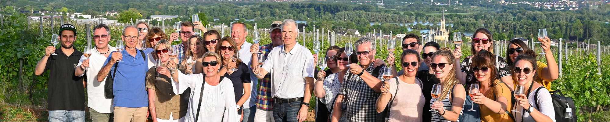 Menschen mit Weinglas in der Hand bei Weinbergsspaziergang durch Erbacher Weinberge